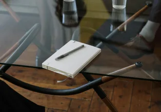 libreta y bolígrafo sobre mesa de madera