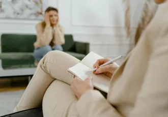 terapeuta tomando notas frente a paciente